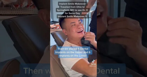 Screencapture from video. Text: Implant Smile Makeover. Traveled from Ohio to Springfield, MO to see Dr. O for same day implant smile makeover! Then we placed 5 dental implants on the upper and 6 implants on the lower.